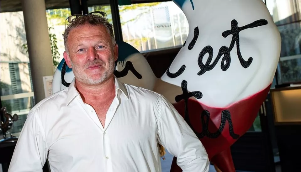 Cédric Soulette prit en photographie devant son coq/oeuvre "Créer c'est résister, résister c'est créer".