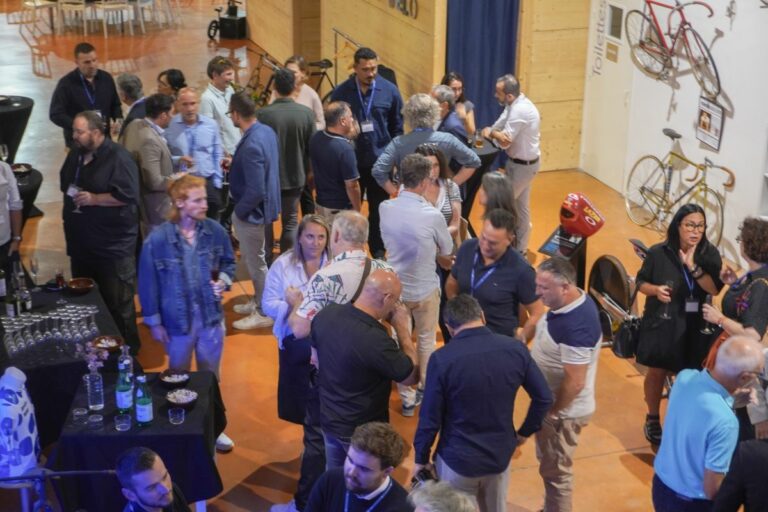 Participants réunis autour d’un buffet au Véloscope, parmi les vélos exposés, lors de la soirée de La Mêlée Ouverte dans le Gers.