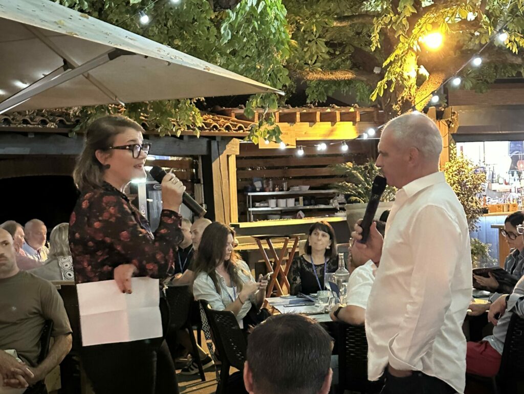Hélène Lasne et Michel Roudière échangent au micro devant les convives, sur la terrasse éclairée de La Pergola.
